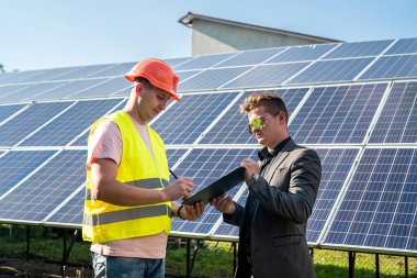 İşçi, patronuna güneş panelleri kurulumunun, yeşil enerji konseptinin,