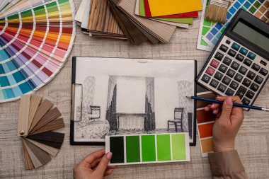 Kadın eli, mimari plan ve yenileme konsepti paletinden bir renk seçer
