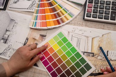 İç mimarın eli paletten bir renk seçer. yenileme konsepti