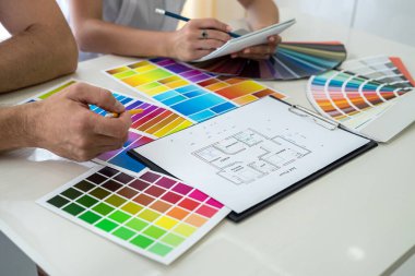 Yaratıcı tasarımcılar dizüstü bilgisayardaki yeni proje hakkında notlar alıyorlar