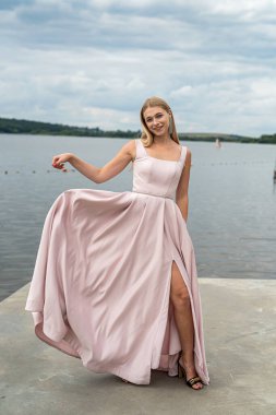 Fantezi büyüleyici kadın zarif bir gece elbisesi içinde göl kenarında dinleniyor, yaz zamanı