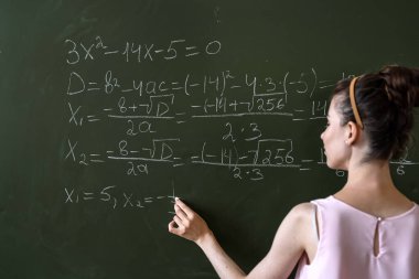 Genç kız öğrenci tahtaya matematik formülleri yazdı, eğitim konseptine. 