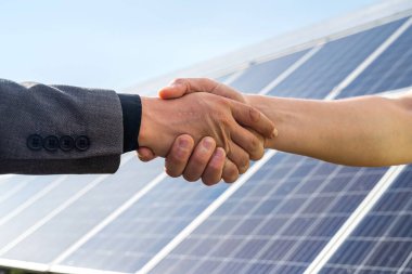 Foreman ve işadamı, anlaşma ya da kontratlarını dağıttıktan sonra el sıkışıyor. Yükselme paneli. Yeşil elektrik