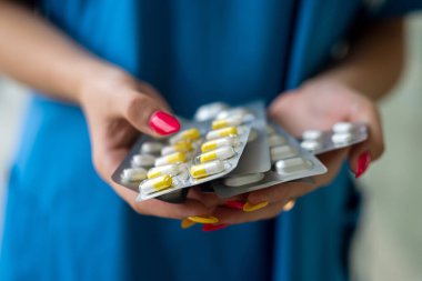 Hemşirenin ellerinde ilaç paketleri vardı.