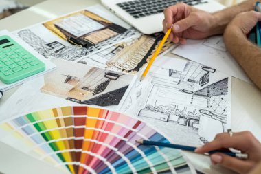 Yaratıcı tasarımcılar dizüstü bilgisayardaki yeni proje hakkında notlar alıyorlar