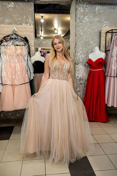 Charming Woman Measures Beautiful Evening Dress Clothing Store Concept Buying — стоковое фото