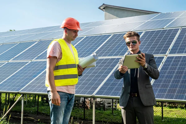 İşçi, patronuna güneş panelleri kurulumunun, yeşil enerji konseptinin,
