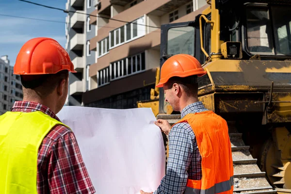 Üniformalı iki zeki işçi inşaat alanında bir ev projesini tartışıyorlar. İnşaat konsepti