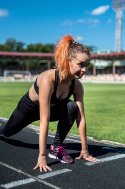 Stadyumdaki seksi bayan atlet eğitimi aktif yaşam tarzı için esnek egzersiz.
