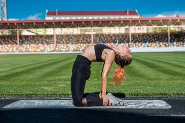 Stadyumda esneme hareketleri yapan bir kadın. fitness konsepti