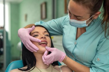 Doktor dişlerini stomatolojik aletlerle tedavi ediyor.