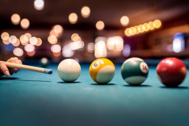 Kadın eli yeşil bilardo masasına bilardo topu doğrultuyor. Yaşam biçimi