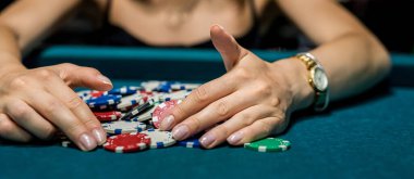 Zarif blöf elbiseli güzel bir bayan kumarhane yeşil masasında kumar oynuyor. Kazanmak için mükemmel bir şans.