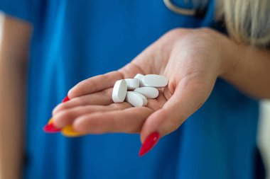 Hemşirenin ellerinde ilaç paketleri vardı.