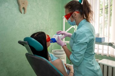 Lambalı ve aynalı doktor hastaların dişlerini tedavi ediyor.