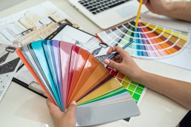 Yeni bir projenin renkleri hakkında konuşmak. Elleri olan tasarımcının işyeri