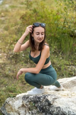 Kum ocağının ya da dağların arkasındaki kayanın yanında şehvetli bir kız. Yolculuk için güneşli bir yaz günü