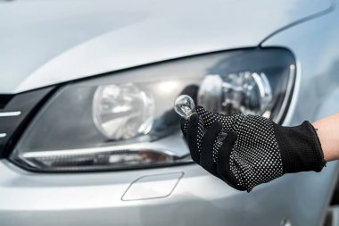 Tamirci arabasındaki ampulü değiştiriyor. teknoloji