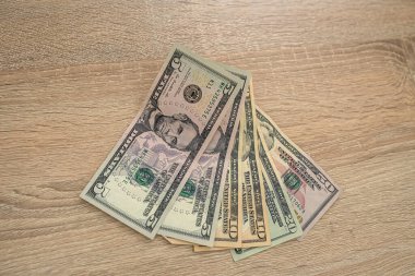 Yeni ahşap bir masanın üzerinde duran araba anahtarlarıyla dolu yeni banknotlar. İş konsepti