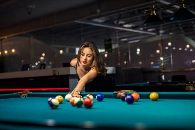 Pub 'da bilardo oynayan neşeli genç bir kadın. Zor bir günün ardından rahatla, yaşam tarzı.