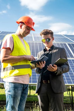 İşçi ve müşteri güneş panelleri başına proje maliyetleri hakkında konuşuyor, tasarruf kavramı