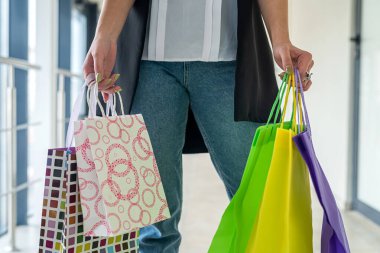Genç bir kadın alışveriş merkezinde, siyah cuma günü şık kıyafetler giyer. Satış ve indirimler