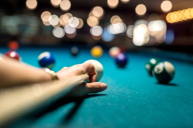 Kadın eli yeşil bilardo masasına bilardo topu doğrultuyor. Yaşam biçimi