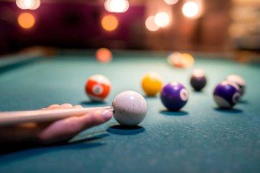 Kadın eli yeşil bilardo masasına bilardo topu doğrultuyor. Yaşam biçimi
