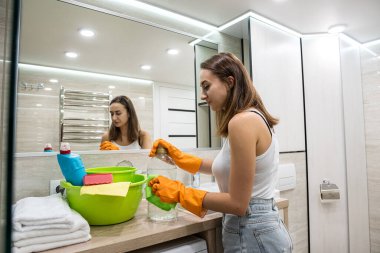 Genç ve güzel bayan temizlik yapıyor. Tuvaletteki temizlik hizmetleri.