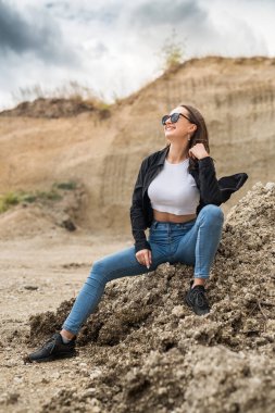 Genç bir kadın kum ocağında hafif egzersizler yapıyor. yoga. Doğada rahatlama. güneşli bir gün