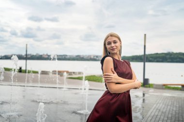 Güzel bir kadın doğada uzun koyu kırmızı bir elbise giyiyor. Seyahat kavramı.