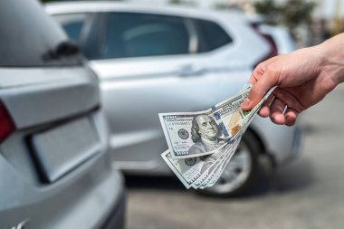 Kiralık ya da araba almak için dolar tutan adam. başarı anlaşması konsepti