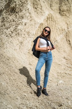  Genç bayan model dışarıda, kum ocağında poz veriyor ve dinleniyor. Çekici kadın dinleniyor.