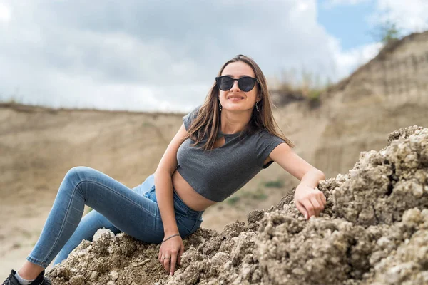 Kafkas kadın modeli kumların altında mavi gökyüzü ile poz veriyor, yaz güneşli bir günde, yaşam tarzında.