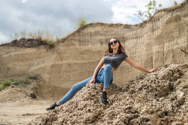 Dişi turist, kum havuzunda zor bir günün ardından oturur ve dinlenir. Güneşli bir günde tatil. özgürlük