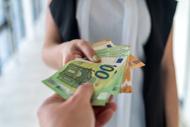 Genç ve güzel bir kızın elleri büyük miktarda yeni Avro banknotları veriyor. İş konsepti