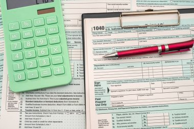 Vergi, yeni ahşap bir masanın üzerinde duran kalem hesap makinesiyle bir tablet üzerinde 1040 formu oluşturur. Belgelendirme kavramı