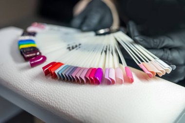 Manikür masasında fanı olan çok renkli oje örnekleri sergileniyor. Manikür kavramı