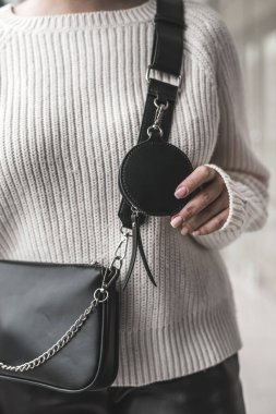 Havalı siyah deri bir çanta tutan zarif bir kadın. Moda konsepti. Gelişmişlik kavramı