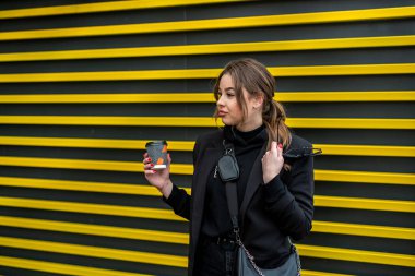 Sonbaharda eşsiz genç bir kız şehrin güzel yerlerinde mutlu bir şekilde yürüyor. Sonbahar konsepti. Şehir konsepti