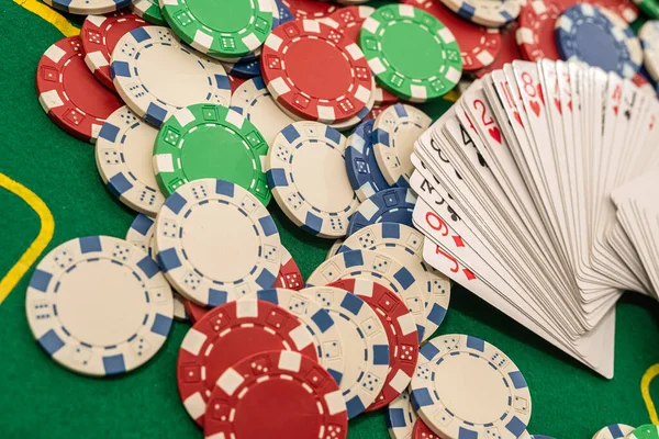 緑のプロのポーカーテーブルの上に色のチップとファンに置かれたカードのデッキ ポーカーのコンセプト ゲームコンセプト — ストック写真