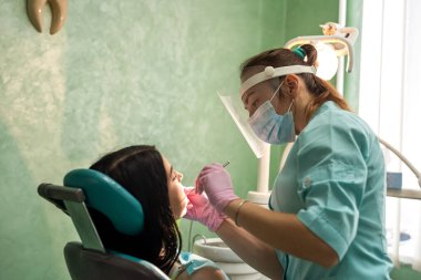 Kafkas kadın doktor dişlerini diş aleti, sağlık ve stomatoloji konseptiyle inceler.