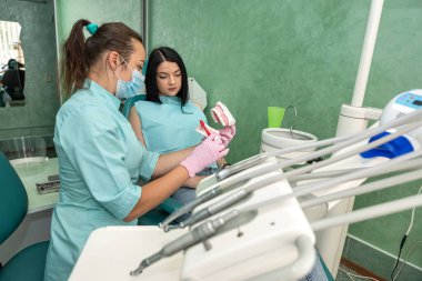 Diş hekimi olan genç bir kadın diş hijyeninden bahsediyor.