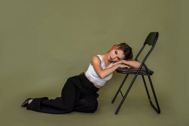 Yeşil arka planda poz veren zarif yeni bir bayan imajı takınan güzel bir genç kız. Tek renkli arkaplanda kadın portresi kavramı