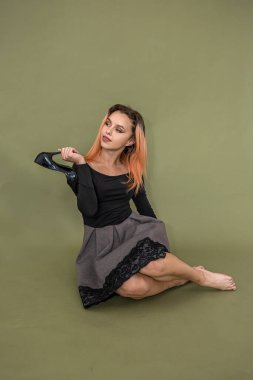 Yeni, güzel bir stüdyoda fotoğraf çekimi için poz veren genç ve güzel bir manken. Kadın portresi konsepti. Sağlam bir arkaplanda çekim kavramı