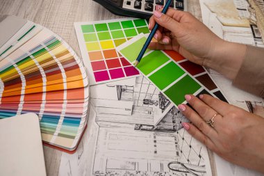 İç mimarın eli paletten bir renk seçer. yenileme konsepti