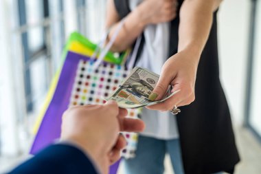 Satın alındıktan sonra elinde renkli poşetlerle dolarları tutan mutlu bir iş kadını. Alışverişkolik kavram