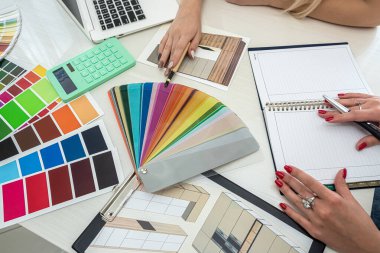 Manikürlü güzel kadın elleri masadaki odaları boyamak için renk örnekleriyle çalışıyor. Örnek konsepti. Renk kavramı. Tasarım konsepti