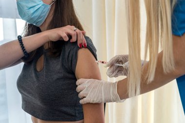 Genç hemşire hastanede koronavirüs aşısı yapıyor. Aşılama kavramı