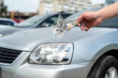 Yeni modern araba almak için para tutan bir adam. Ödeme